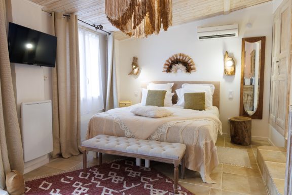 Chambre confortable avec lit double, déco chaleureuse et télévision murale.