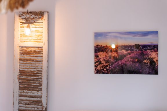 Un coucher de soleil sur un paysage floral, accroché à un mur blanc.