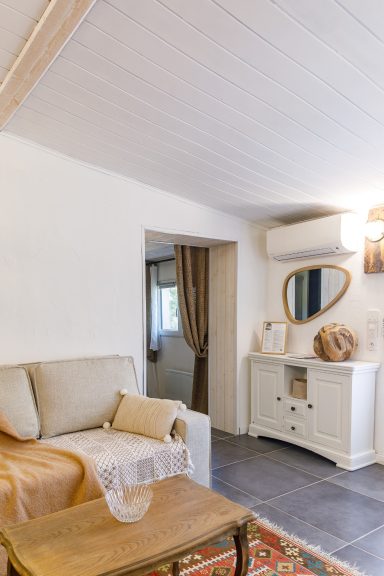 Salon lumineux et raffiné à La Bastide du Mûrier à Cotignac appartement Tahaa Salon lumineux avec un canapé crème, une table basse en bois et un meuble blanc.