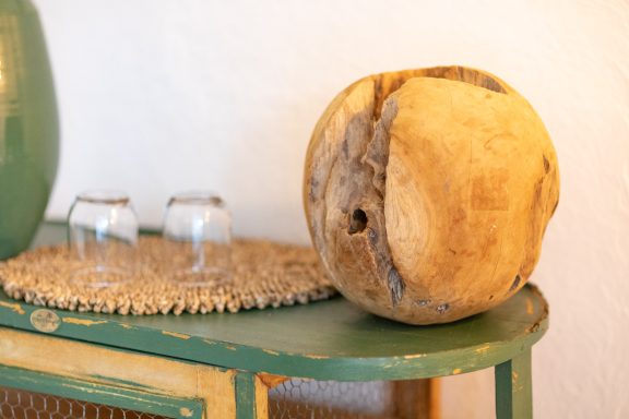 Boule en bois posée sur une table avec des verres à côté.