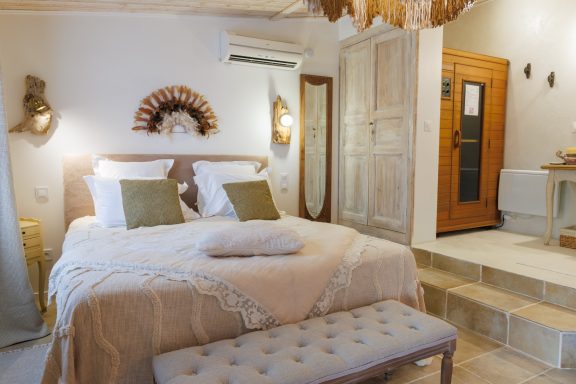 Chambre lumineuse avec lit double, décoration élégante et accès à une salle de bain.